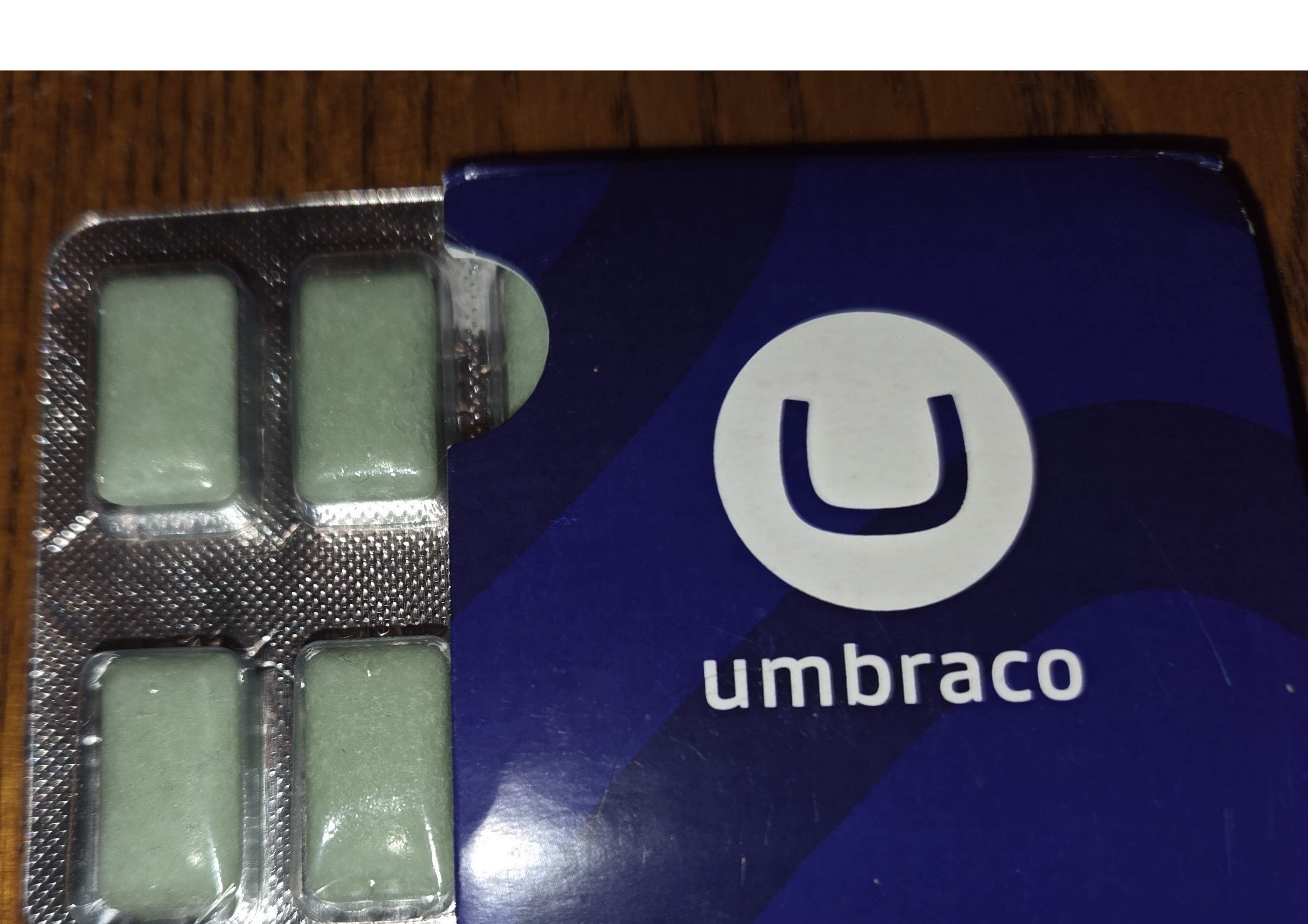 4 pieces of green chewing gum, coming out of a squad box with Umbraco logo on it